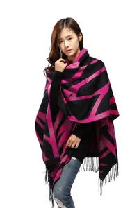 Close-up of geometric diamond pattern and long tassels on black knit cashmere poncho
