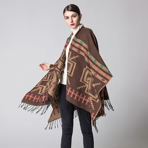 Detail of bohemian knit shawl with ethnic geometric patterns and tassel hem detail