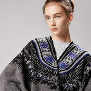 Macro shot of ethnic geometric jacquard weaving details on a grey knitted poncho shawl