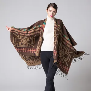 Close-up of bohemian knit shawl with geometric patterns and long black tassel fringe
