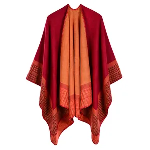 Detail of the thick knit texture and red plaid pattern on a reversible warm poncho shawl