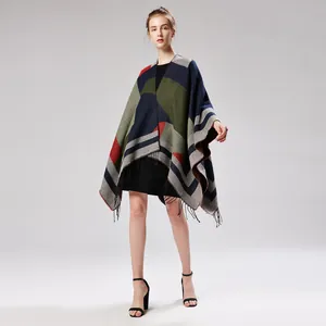 Detail of knitted poncho featuring geometric color-blocking pattern and fringe hem