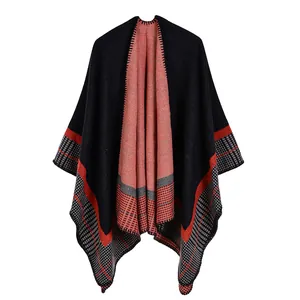 Detail of black knit shawl with orange and gray geometric patterns and fine stitching