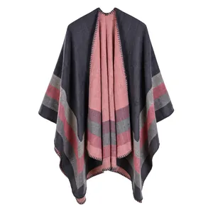 Navy blue knitted poncho with pink and grey stripes and blanket stitch edge