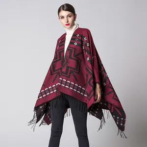 Ethnic style knitted poncho shawl in burgundy with geometric patterns and black tassels