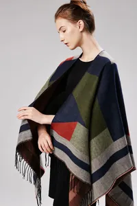 Detail view of geometric patchwork pattern and fine tassel fringe on women's knit shawl