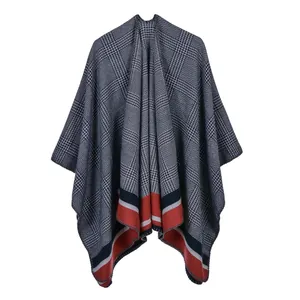 Close-up of knit shawl detailing grey plaid pattern and navy blue striped borders