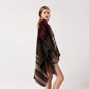 Détail d'un châle en maille bohème aux motifs géométriques rouge foncé et vert forêt