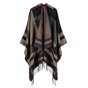 Detail of bohemian geometric patchwork knit shawl with fringe hem and multi-color patterns