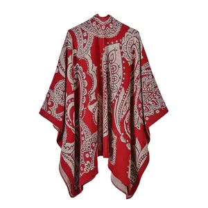 Dettaglio di scialle rosso con motivo paisley e trame di anacardi in tessuto spesso invernale