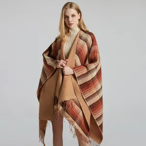 Detailed view of tartan plaid pattern and soft tassel fringe on the winter cape