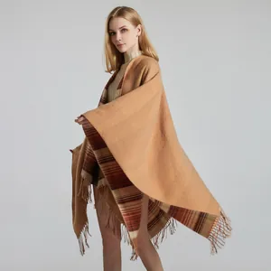Close-up of camel cashmere shawl with classic red plaid lining and tassel details