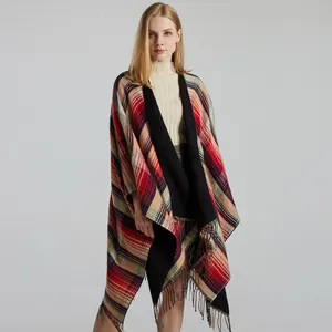 Detailed view of red and black plaid wrap with tassel hem and thick cashmere-like texture