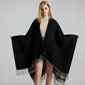 Detail of black knit shawl with tassels and black-white striped inner lining detail