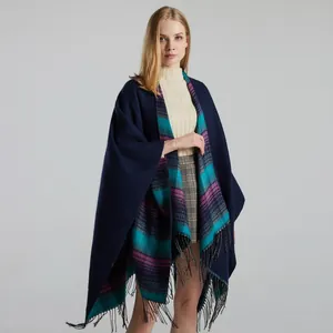 Detail of navy blue reversible shawl with plaid interior and elegant fringe hem