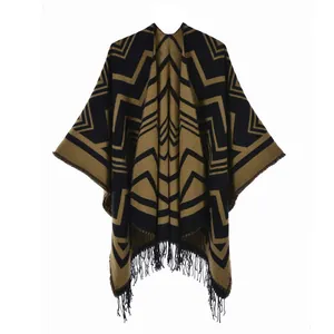 Detail eines Ponchos mit geometrischem Strickmuster, Ethno-Stil und schwarzen Fransen