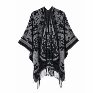 Detail of bohemian black and grey paisley knit shawl with long fringe tassels