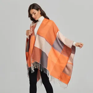Detail of geometric orange and grey knit scarf featuring elegant long fringe tassels