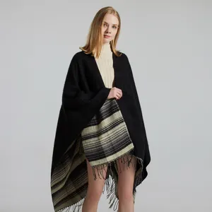 Close-up of black cashmere-like shawl with classic plaid lining and fringe details