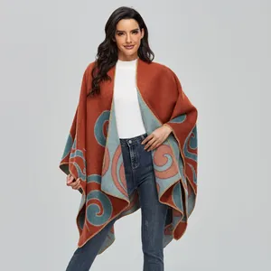 Detail of vintage rust red knit poncho with blue paisley patterns and overcast edges