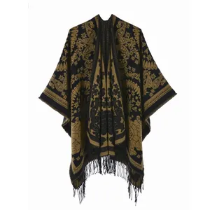 Detailed close-up of ethnic paisley pattern and long tassels on this vintage black gold shawl