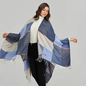 Detail of color-block knit shawl featuring soft navy and beige tones with fine fringe edges