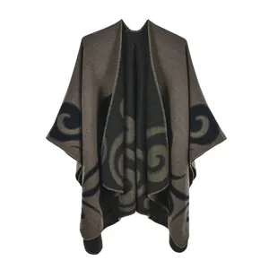 Detailed close-up of brown knit poncho with black spiral patterns and stitched edges