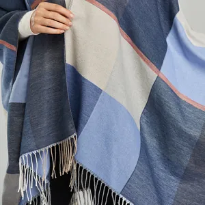 Detail of vintage jacquard check pattern and soft fringe edges on a warm shawl cape