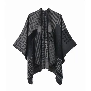 Detail of the knit texture and geometric pattern of the grey double-sided poncho cape