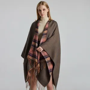 Close-up of thick plaid shawl with brown fringe and orange blue checkered lining