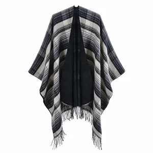 Detail view of Scottish style plaid poncho featuring soft black and white fringe tassels