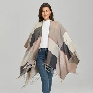 Detail of a women's vintage geometric block poncho with fine fringe and soft texture