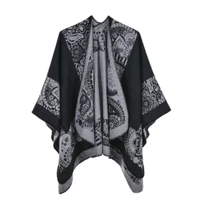 Macro detail of knit poncho shawl featuring vintage paisley and grey floral patterns