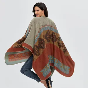 Dettaglio di poncho in maglia etnica con motivi geometrici colorati e bordi rifiniti