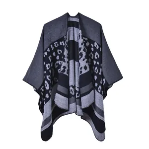 Detail eines grauen Ponchos mit Leopardenmuster, Strickstruktur und präziser Kettelung