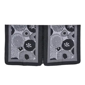 Detailed view of women's black and grey shawl with abstract floral woven pattern