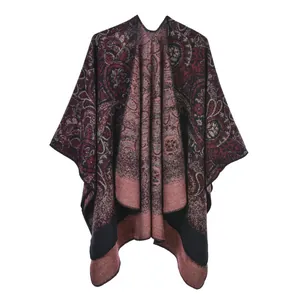 Detail of burgundy paisley knitted poncho with warm fringe edges and ethnic patterns