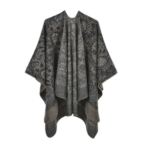 Detail of paisley knit poncho showing thick grey fabric and fine stitched edge craft