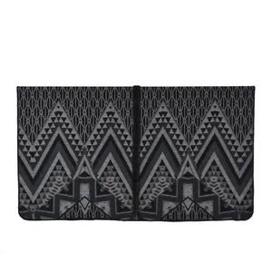 Detailed view of geometric jacquard patterns on black and grey shawl cape
