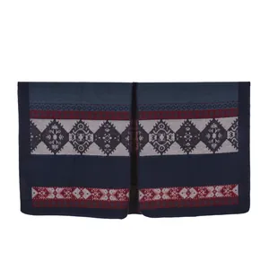 Detailed view of ethnic geometric knit patterns and fringes on a navy warm poncho