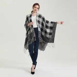Detail view of classic gray plaid poncho with fringe hem on female model
