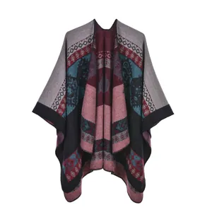 Detail of ethnic knit poncho showing geometric patterns and burgundy tassel hem