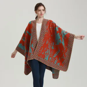 Women's thick knit poncho shawl featuring vibrant orange and teal geometric patterns