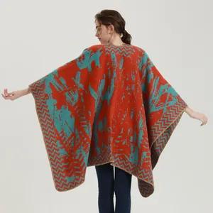 Thick knitted poncho wrap in orange and teal blue with abstract patterns for winter