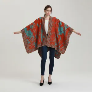 Detail view of oversized knitted poncho featuring orange and green abstract patterns
