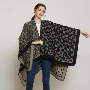 Détail du poncho en maille avec motifs cachemire complexes et bordure contrastée