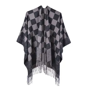 Detailed view of the knit shawl featuring classic black and grey plaid pattern with tassels