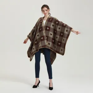 Detailmuster des ethnischen Strickponchos mit braunem Herz-Jacquard und Karos