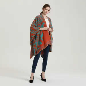 Detail van bohemien gebreide sjaal met oranje basis, blauwe bloemen en fijne stiksels