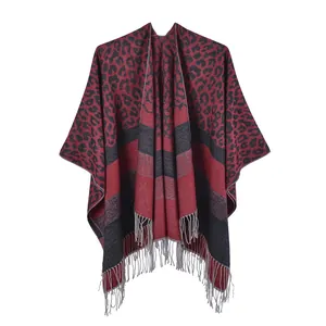 Close-up of red and black leopard print knit shawl with soft fringe tassels and texture